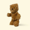 Small Brown Hairy Barry dog toy teddy bear on a beige background