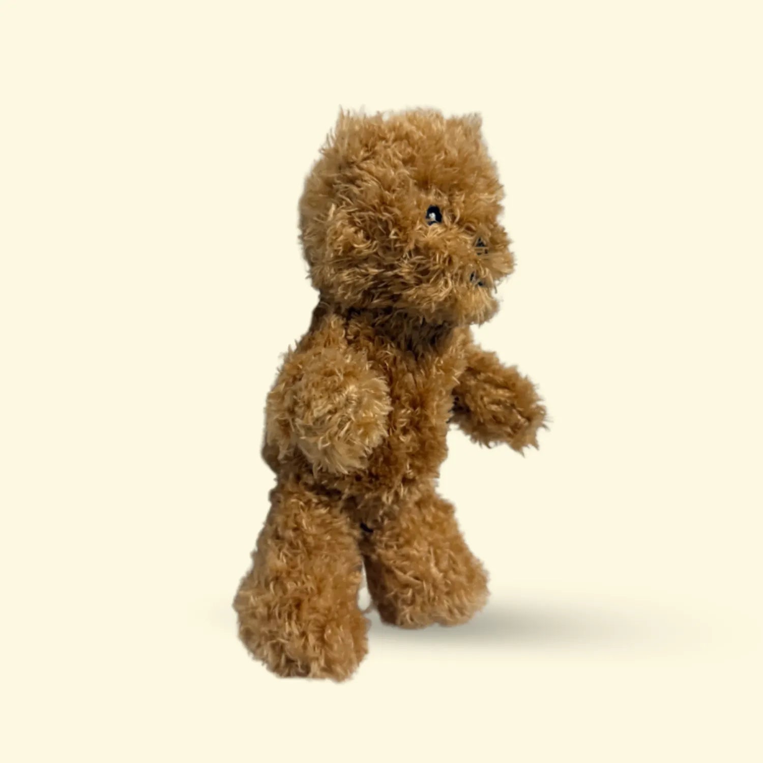 Small Brown Hairy Barry teddy bear dog toy on a beige background